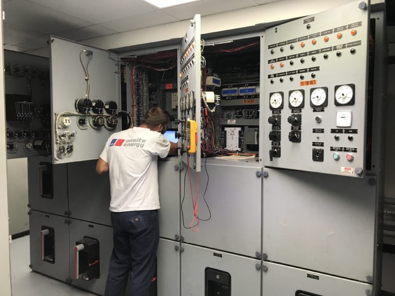 technician servicing a switch gear control panel